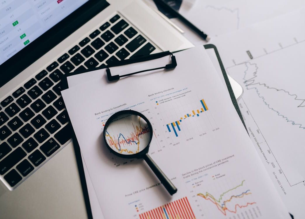 overhead view of financial charts with magnifying glass